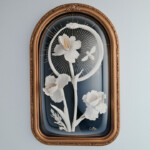 Lana Filippone, “Artemisia vulgaris, Pythia Ouroborus.”, porcelain sculpture, glazes, 24k gold lustre, gold leaf, indigo velvet, domed frame, 19.6 x 11.5 inches, $4,000 | Artemis of Ephesus, a Goddess attributed by bees